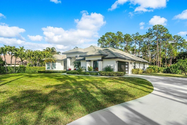 view of front of house featuring concrete driveway, stucco siding, an attached garage, and a front yard