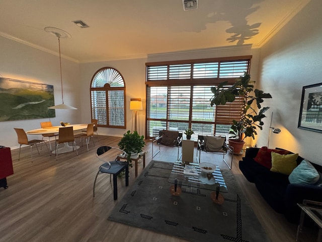 living room with wood finished floors, visible vents, and crown molding