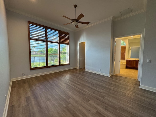 unfurnished room featuring crown molding, baseboards, and wood finished floors