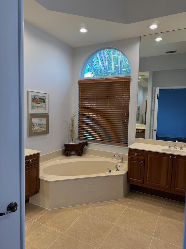 bathroom with recessed lighting, tile patterned flooring, a bath, and vanity