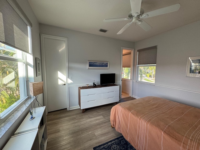 bedroom featuring ceiling fan, wood finished floors, visible vents, and baseboards