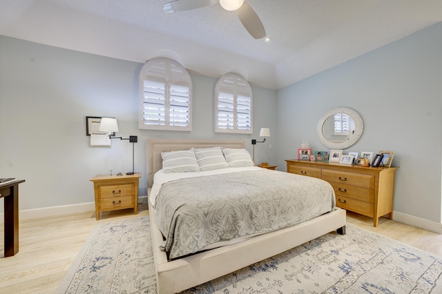 bedroom with light wood-style flooring, baseboards, and a ceiling fan