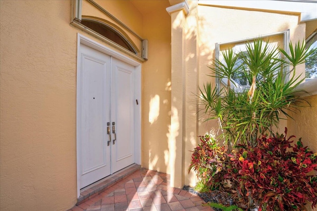 view of exterior entry with stucco siding