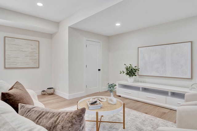 living room with light wood finished floors, recessed lighting, and baseboards