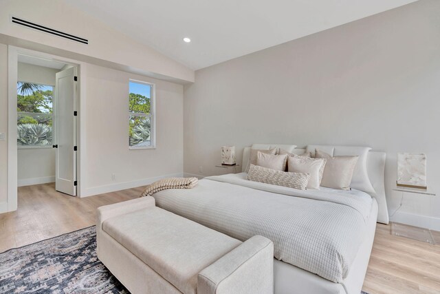 bedroom with baseboards, lofted ceiling, wood finished floors, access to outside, and recessed lighting