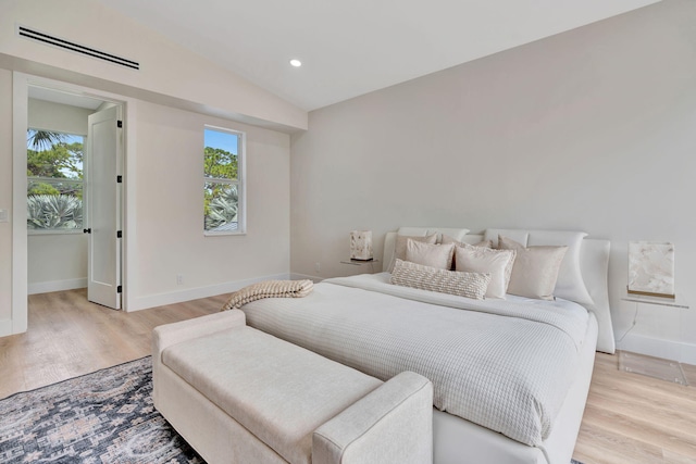 bedroom featuring light wood-style floors, recessed lighting, visible vents, and baseboards