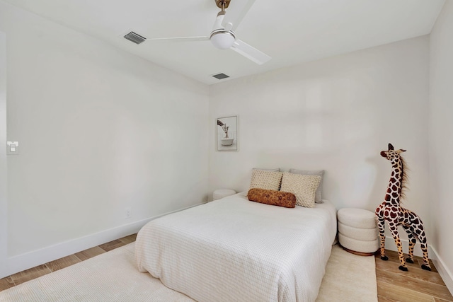 bedroom with light wood finished floors, a ceiling fan, visible vents, and baseboards