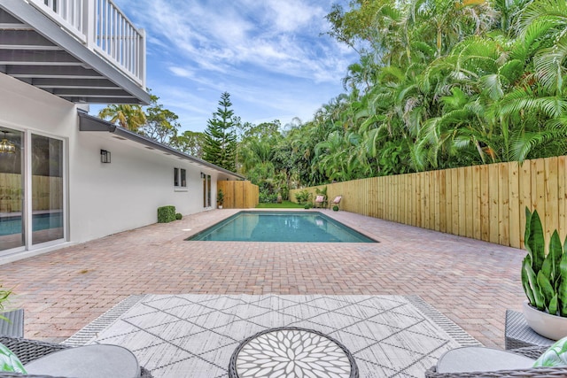 view of swimming pool featuring a fenced in pool, a fenced backyard, and a patio