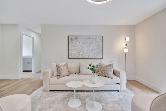 living area with light wood-style flooring and baseboards