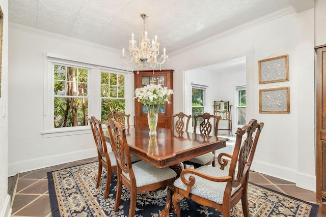 dining room featuring baseboards, a chandelier, crown molding, and dark tile patterned flooring