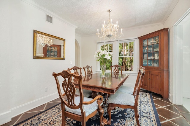 dining space featuring arched walkways, visible vents, ornamental molding, a chandelier, and baseboards