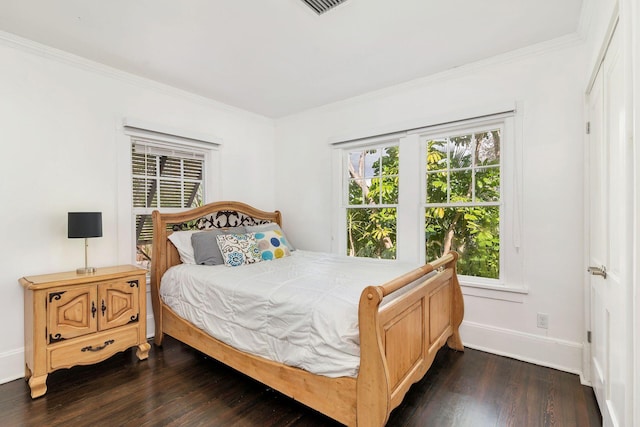 bedroom with crown molding, baseboards, and dark wood-type flooring