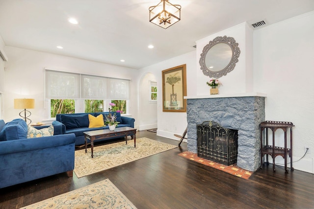 living room with dark wood-style floors, baseboards, a fireplace, and visible vents