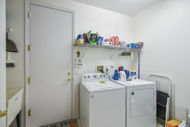 washroom featuring a sink, laundry area, and washing machine and clothes dryer