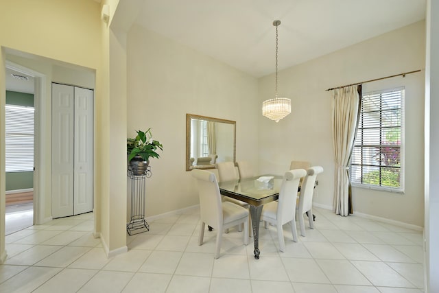 dining space featuring light tile patterned flooring, baseboards, and an inviting chandelier