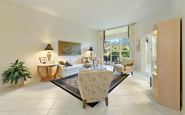 living area with tile patterned flooring, arched walkways, a wall of windows, and baseboards