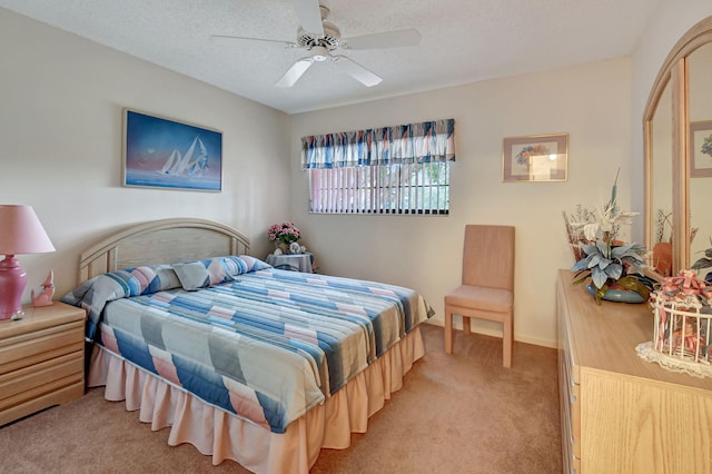 bedroom featuring light carpet, a textured ceiling, and a ceiling fan