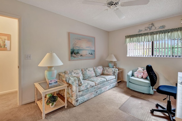 carpeted living area with a textured ceiling, ceiling fan, and baseboards