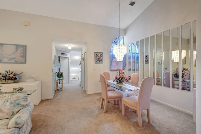 dining space featuring baseboards, visible vents, a chandelier, and light colored carpet