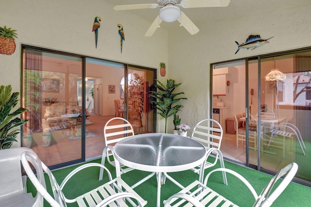 tiled dining room featuring a textured wall, a sunroom, and a ceiling fan