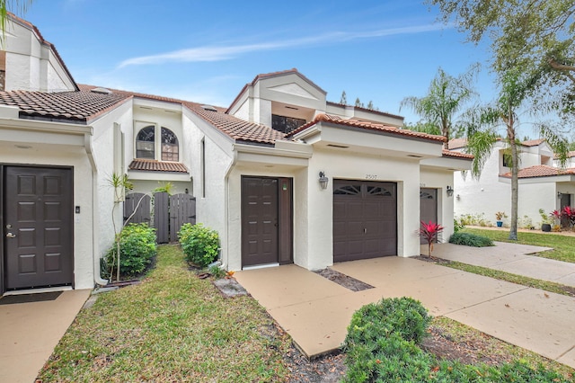 view of front facade with a garage, concrete driveway, a tiled roof, and stucco siding