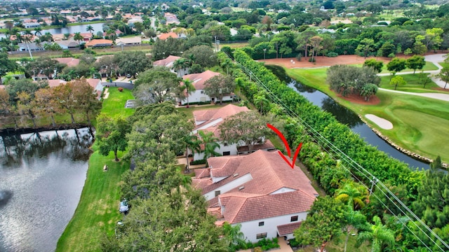 drone / aerial view featuring a water view, view of golf course, and a residential view