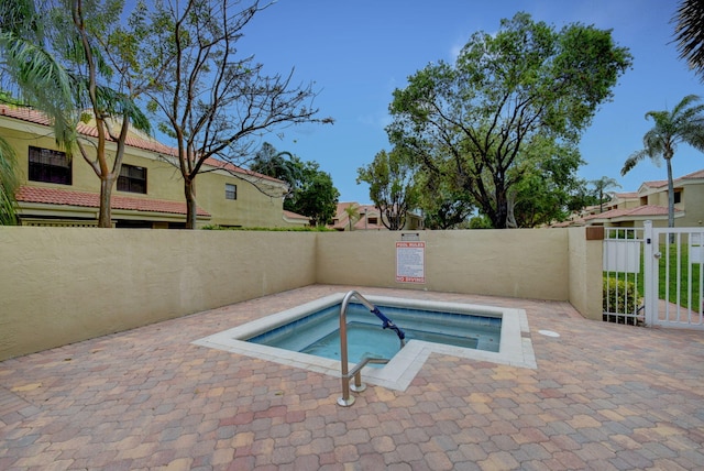 view of swimming pool with a fenced backyard, a residential view, and a hot tub