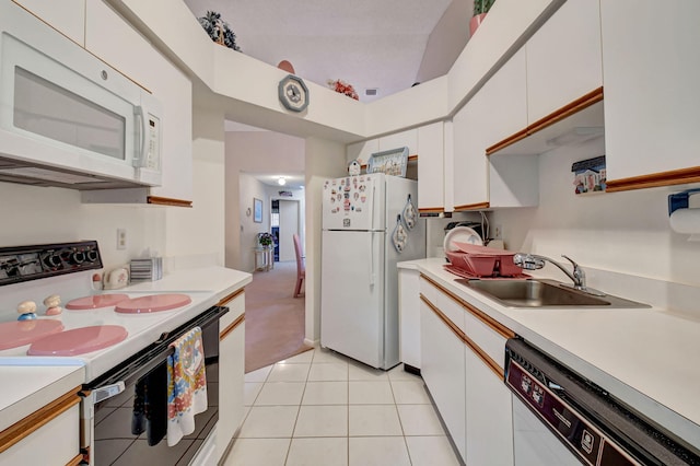 kitchen featuring light tile patterned floors, light countertops, white cabinets, a sink, and white appliances