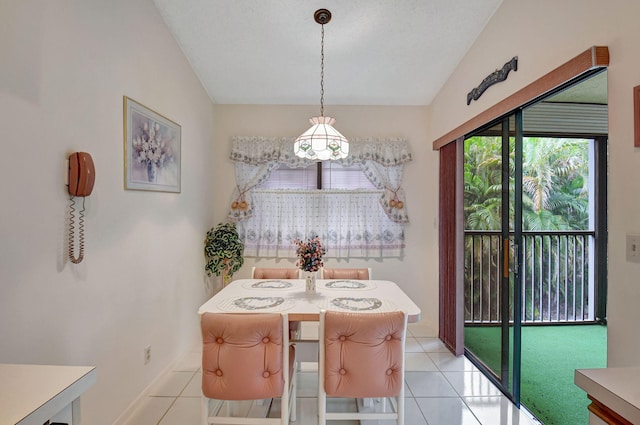 dining room featuring light tile patterned flooring and vaulted ceiling