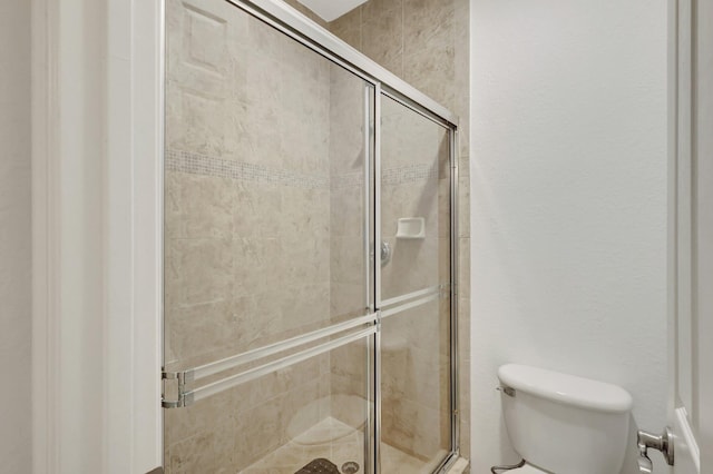 bathroom with toilet and a shower stall