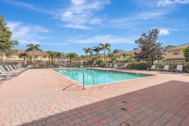 pool with a residential view, fence, and a patio