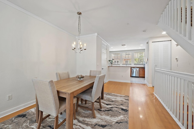 dining room featuring baseboards, stairway, light wood-type flooring, a notable chandelier, and recessed lighting