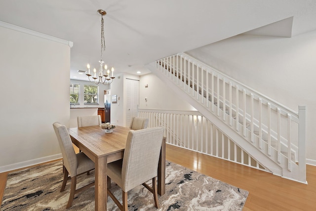 dining space featuring baseboards, recessed lighting, wood finished floors, and a notable chandelier