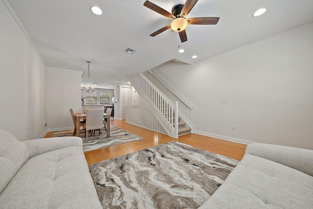 living area featuring stairs, visible vents, wood finished floors, and recessed lighting