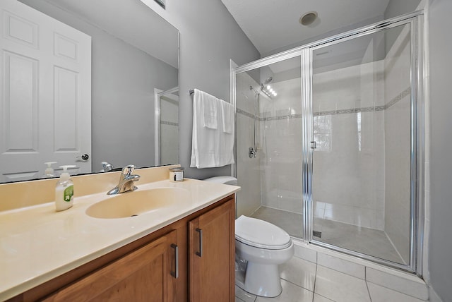 bathroom featuring a stall shower, vanity, toilet, and tile patterned floors