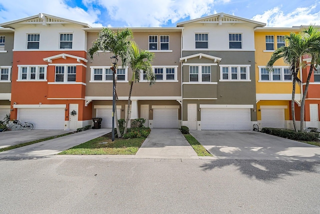 multi unit property with driveway, an attached garage, and stucco siding