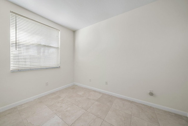 spare room with baseboards