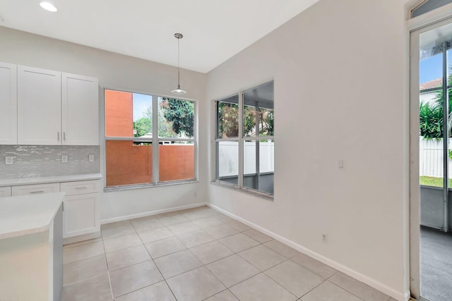 unfurnished dining area featuring light tile patterned floors and baseboards