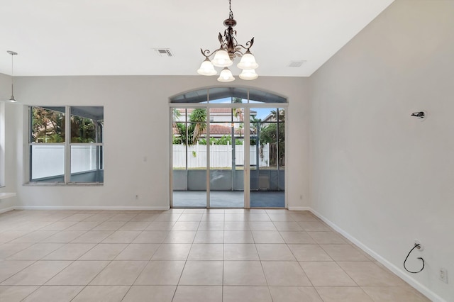 empty room featuring baseboards, light tile patterned flooring, visible vents, and an inviting chandelier