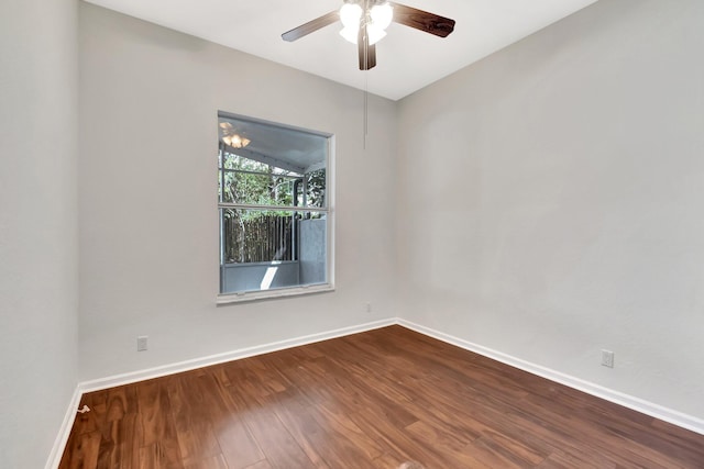 empty room with a ceiling fan, dark wood-style flooring, and baseboards