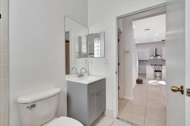 bathroom featuring toilet, visible vents, vanity, backsplash, and tile patterned floors