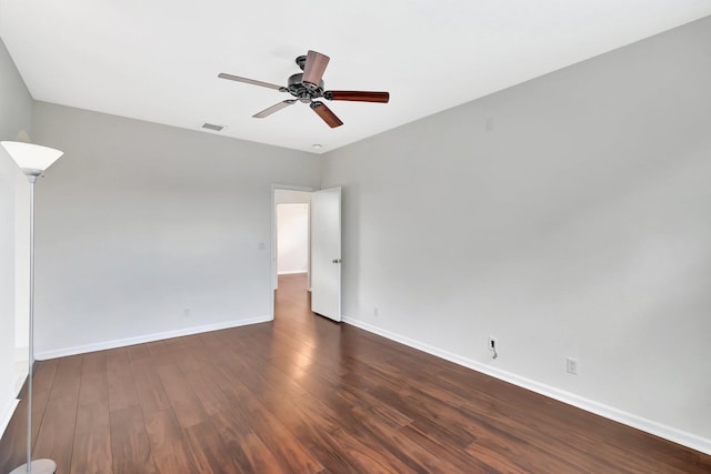 empty room featuring a ceiling fan, baseboards, visible vents, and wood finished floors