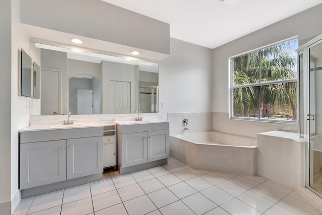 bathroom featuring a stall shower, tile patterned flooring, a garden tub, and vanity