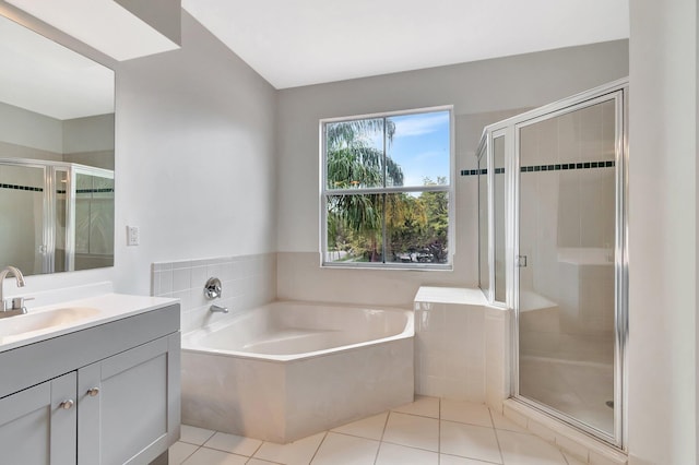 bathroom with a stall shower, tile patterned floors, a bath, and vanity