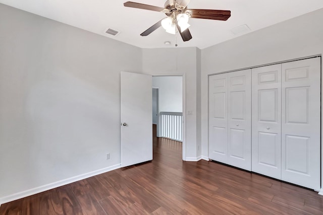 unfurnished bedroom featuring a closet, wood finished floors, visible vents, and baseboards