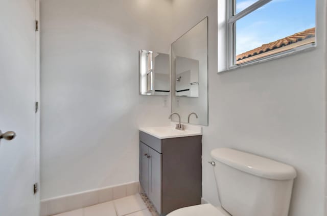 bathroom featuring baseboards, vanity, toilet, and tile patterned floors