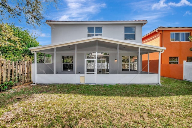 back of house featuring a lawn, fence, and a sunroom