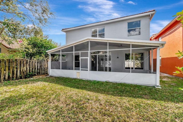 back of house with a sunroom, fence, and a lawn