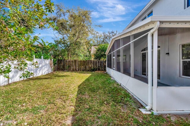 view of yard with fence private yard and a sunroom