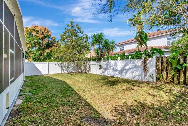 view of yard featuring a fenced backyard and a lanai